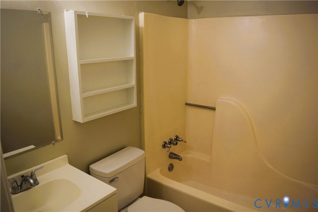 8905 Hawkbill Road, Chesterfield, VA 23237 Full bathroom featuring a molded composite tub and shower surround, wall-mounted storage cabinetry, vanity with integrated basin, and polished chrome plumbing fixtures