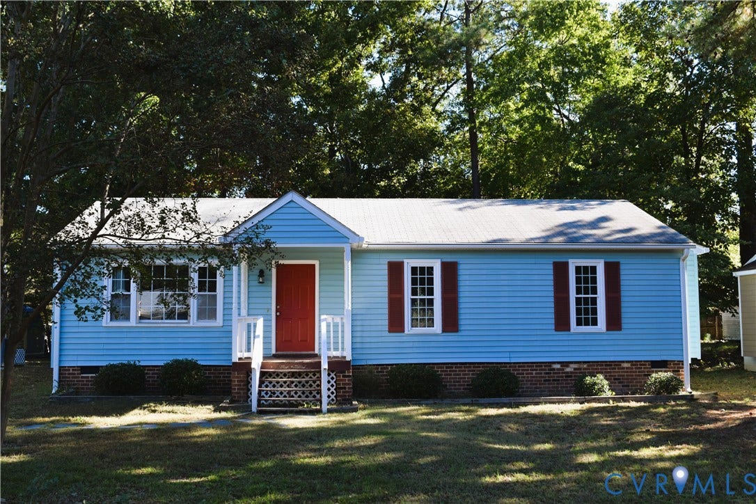 8905 Hawkbill Road, Chesterfield, VA 23237 Single-story exterior featuring light blue horizontal siding, a red front door, brick foundation skirting, shuttered windows, and a covered front porch with white railing