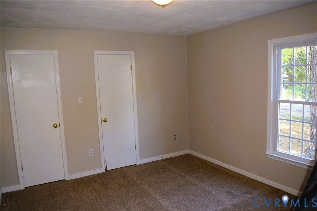 8905 Hawkbill Road, Chesterfield, VA 23237 Neutral-toned interior room featuring wall-to-wall carpeting, two interior doors, and a multi-pane window with white trim