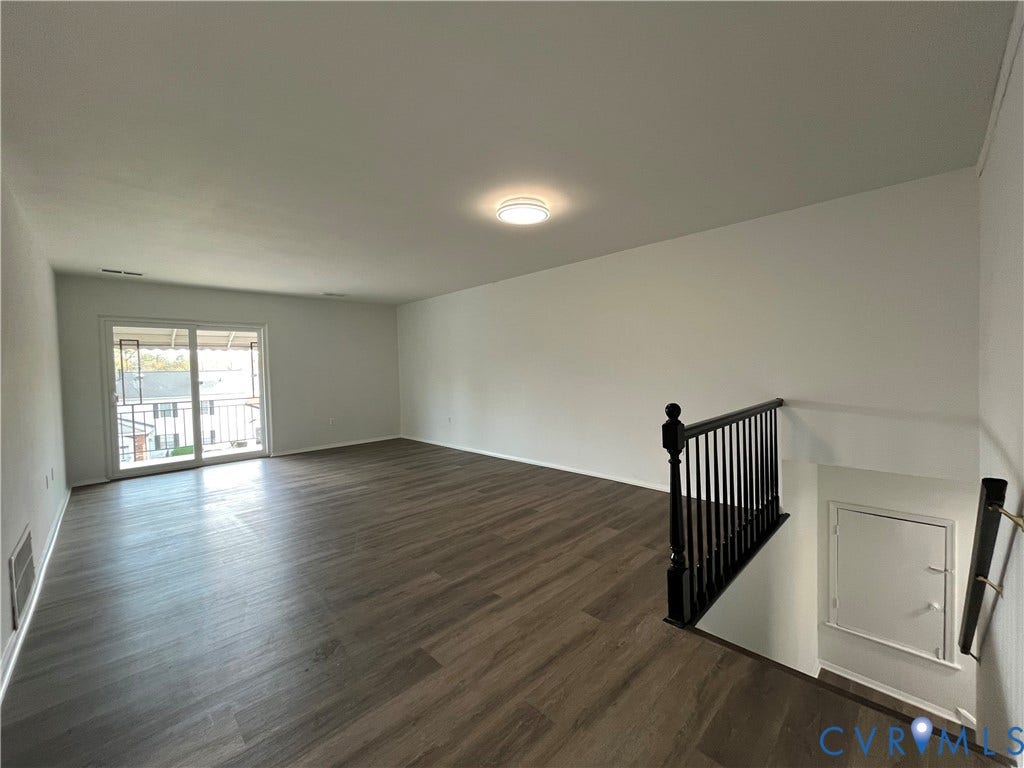 39 Rock Garden Lane, Henrico, VA 23228 Open-concept room featuring wood-finish flooring, sliding glass door, flush-mount ceiling lighting, and a black metal spindle railing