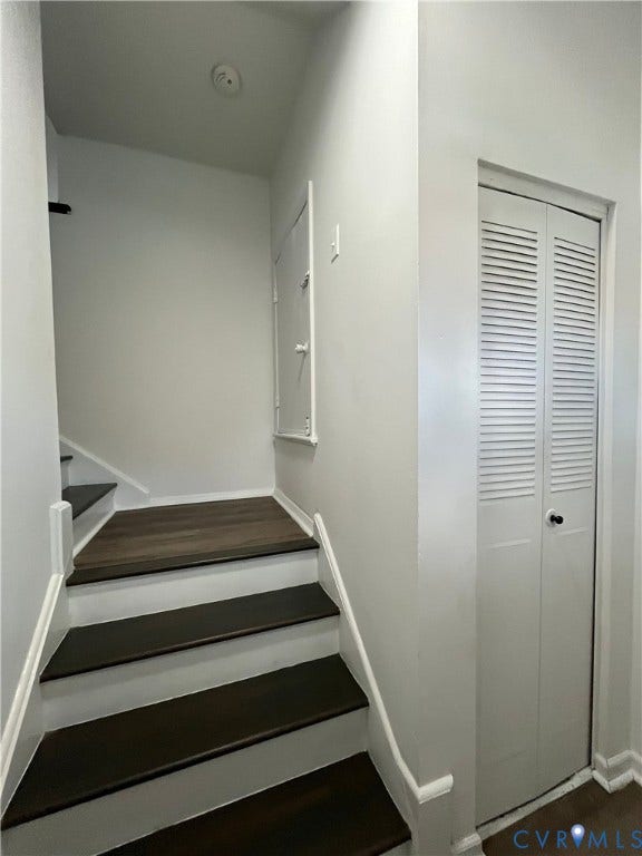 39 Rock Garden Lane, Henrico, VA 23228 Staircase featuring wood-finish treads and white risers, accompanied by a bi-fold louvered closet door