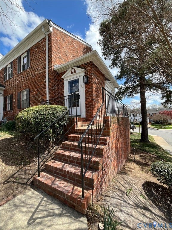 39 Rock Garden Lane, Henrico, VA 23228 Classic brick exterior featuring a raised entry staircase, wrought iron railings, and a pedimented door surround