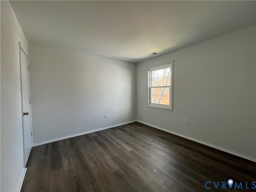 39 Rock Garden Lane, Henrico, VA 23228 Neutral-toned interior space featuring wood-finish flooring, a single-hung window with a grille pattern, and a hinged closet door