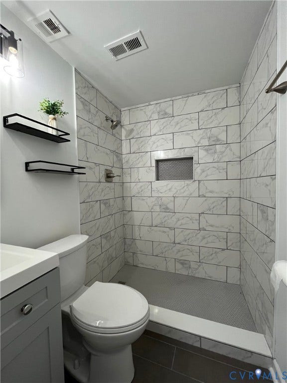 39 Rock Garden Lane, Henrico, VA 23228 Walk-in shower featuring large-format stone-look wall tiling, a built-in recessed niche, and a tiled floor, accented by a grey vanity cabinet and metal wall-mounted shelving