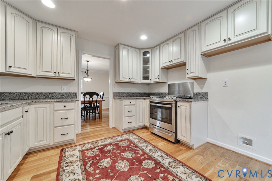 Kitchen featuring white cabinetry, stone-finish countertops, stainless steel gas range, and wood-finish flooring