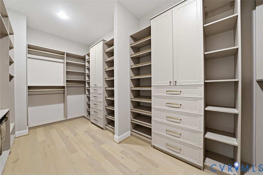 18132 Dogwood Trail Way, Rockville, VA 23146 Walk-in closet featuring custom built-in cabinetry, floor-to-ceiling shelving, integrated drawer banks, metallic hardware, and wood-finish flooring