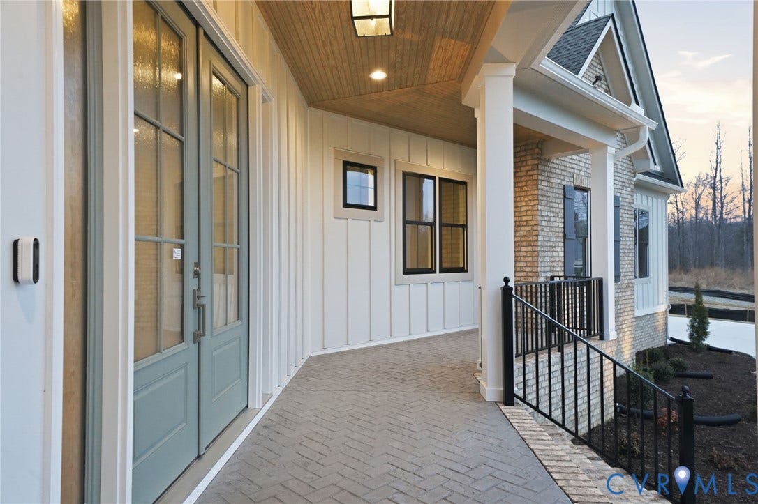 18132 Dogwood Trail Way, Rockville, VA 23146 Covered entryway featuring board-and-batten siding, a brick facade, herringbone-patterned brick pavers, a wood-finish ceiling, and double glass-pane doors