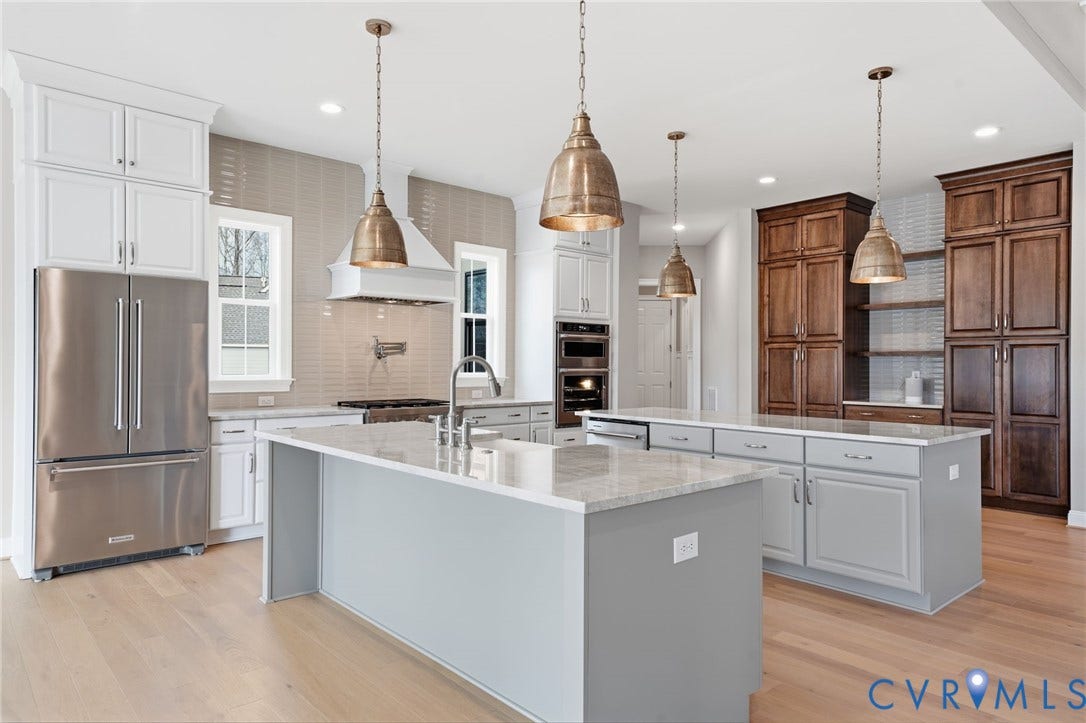 18132 Dogwood Trail Way, Rockville, VA 23146 Kitchen featuring a stone-topped central island, stainless steel appliances, built-in double wall ovens, wood-finish cabinetry, and metal pendant lighting