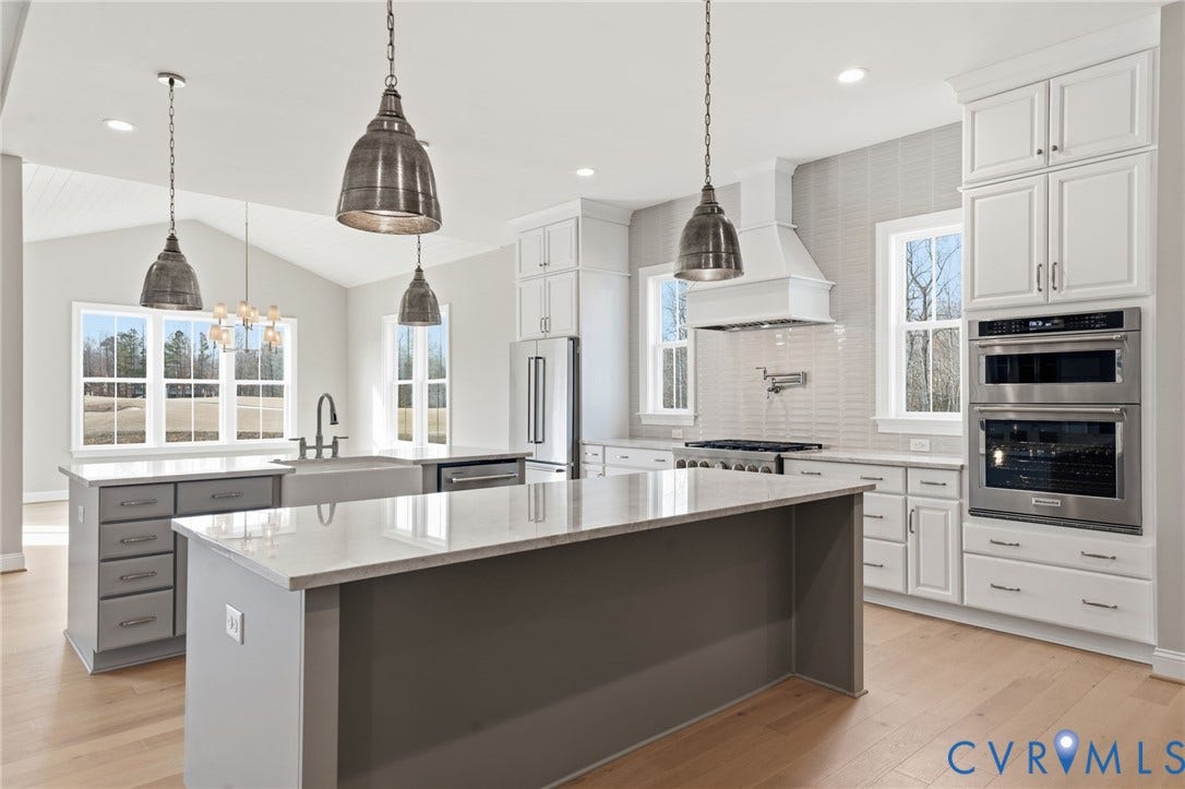 18132 Dogwood Trail Way, Rockville, VA 23146 Kitchen featuring white cabinetry, an oversized central island with stone-finish countertops, stainless steel double wall ovens, a farmhouse sink, and pendant lighting