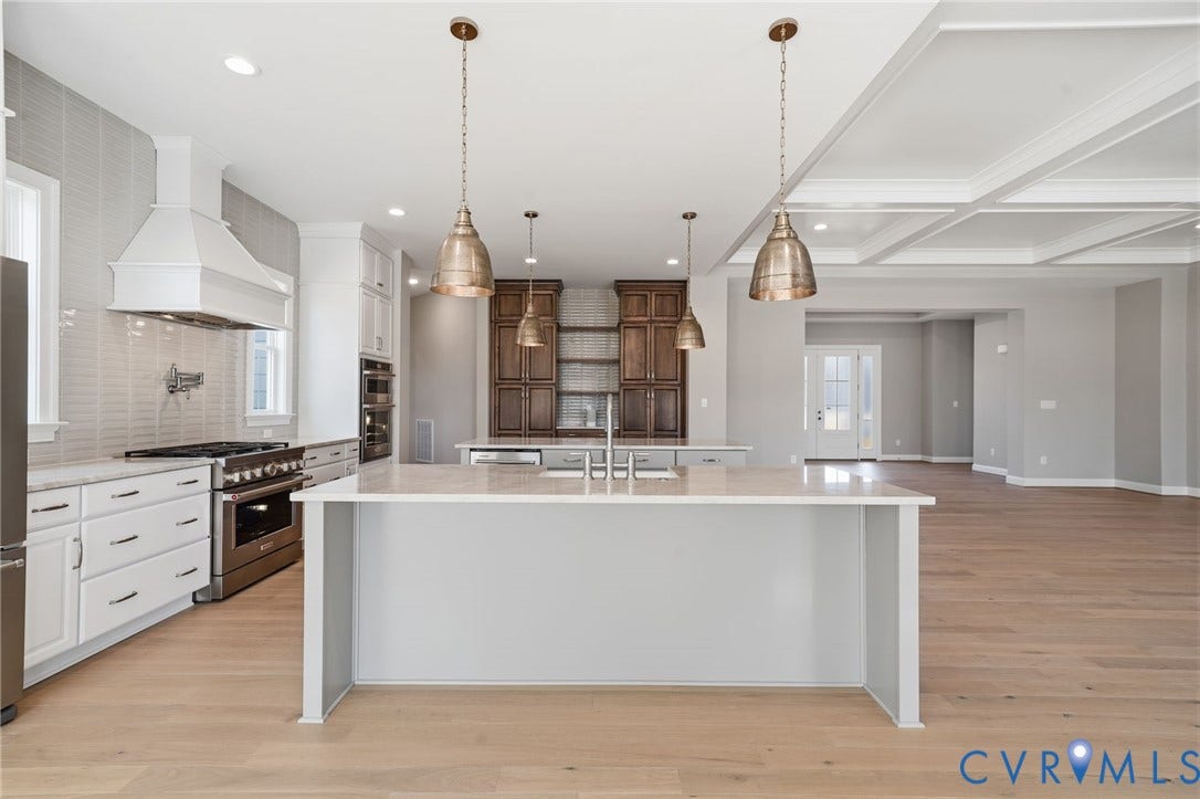 18132 Dogwood Trail Way, Rockville, VA 23146 Kitchen featuring a center island with countertop seating, wood-finish flooring, custom cabinetry with integrated stainless steel appliances, a tile backsplash, and coffered ceiling detailing