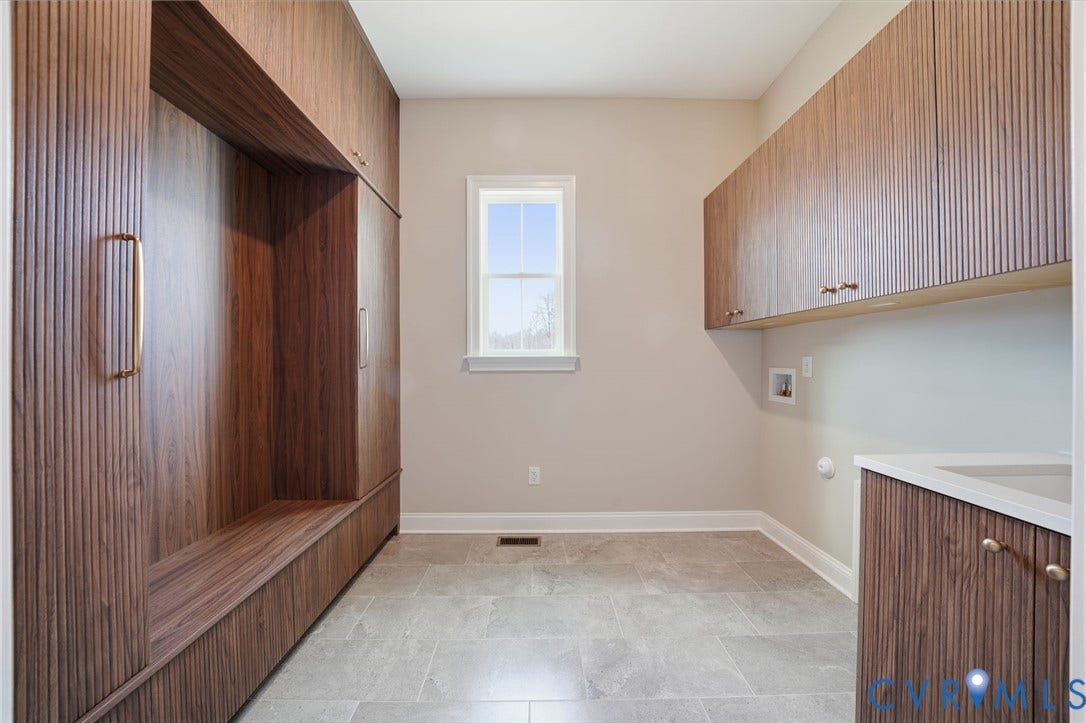 18132 Dogwood Trail Way, Rockville, VA 23146 Custom fluted wood-finish cabinetry, stone-composite tile flooring, integrated storage shelving, and a neutral countertop with an under-mount sink