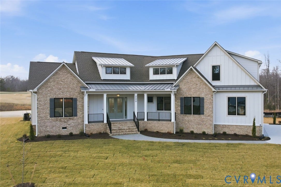 18132 Dogwood Trail Way, Rockville, VA 23146 Custom-built exterior featuring a multi-material facade of brick and vertical siding, dual shed dormers, standing-seam metal roofing accents, and a covered front porch with iron railings