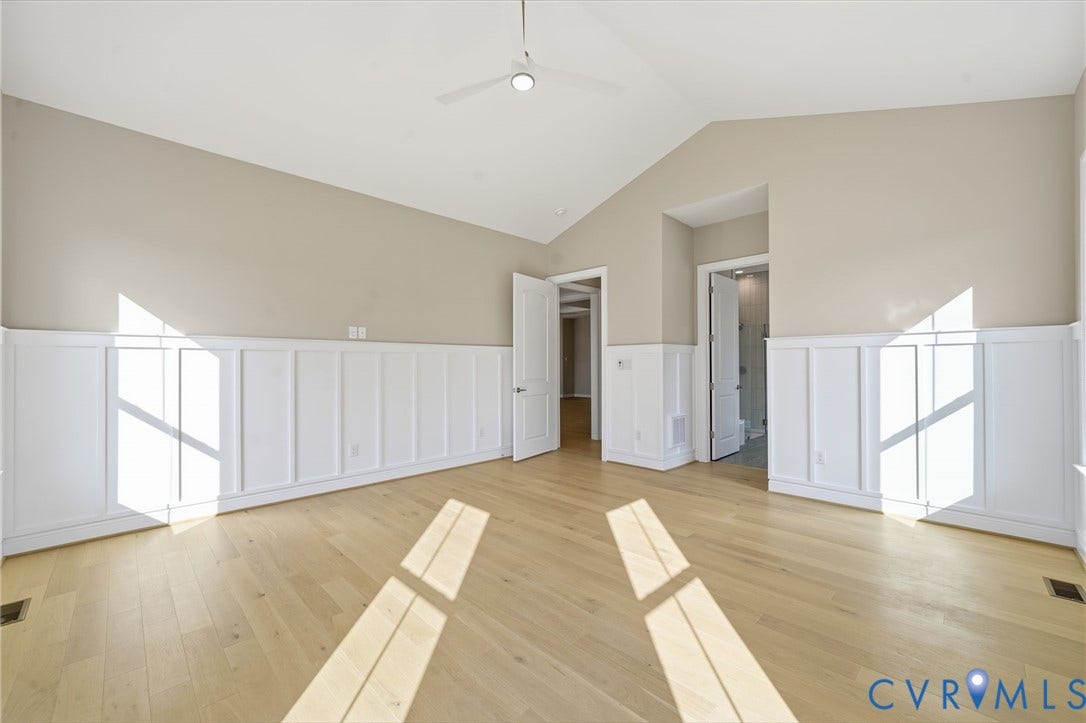 18132 Dogwood Trail Way, Rockville, VA 23146 Vaulted ceiling with a central white ceiling fan, wood-finish flooring, and white wainscoting encompassing the lower walls