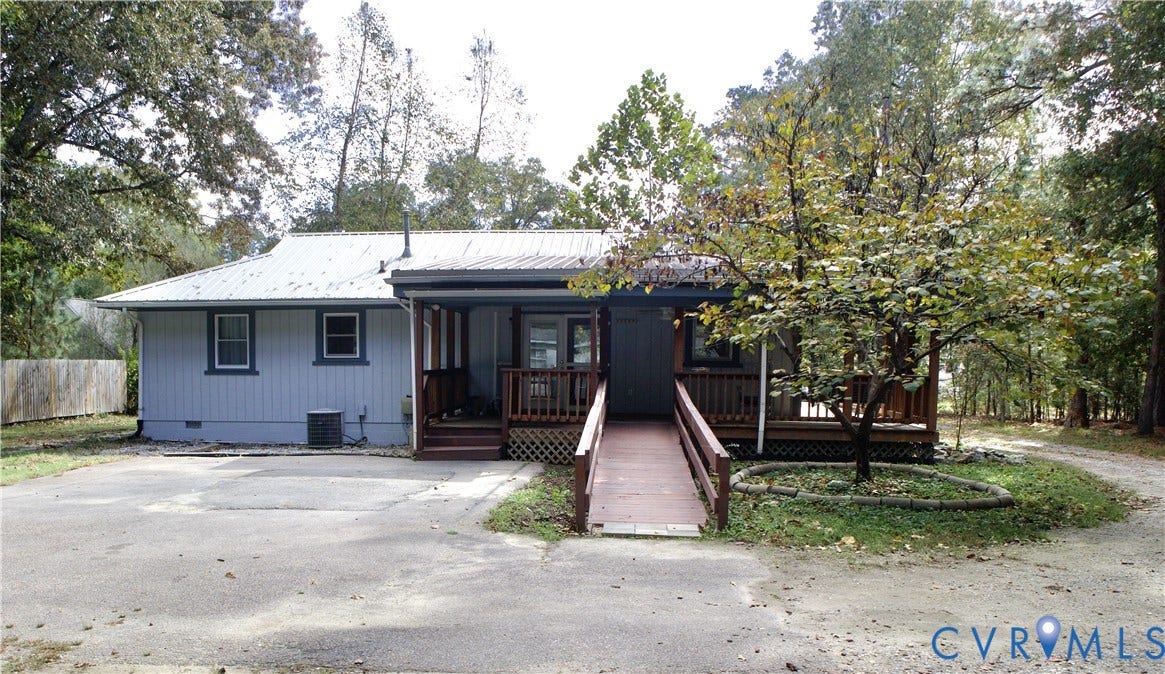9012 Shawonodasee Road, Courthouse, Chesterfield, VA 23832 Single-story residence featuring light-toned vertical siding, a metal roof, an expansive wood-finished deck, and a dedicated ramp structure