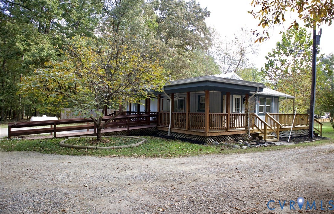 9012 Shawonodasee Road, Courthouse, Chesterfield, VA 23832 Single-story exterior featuring light-toned siding, a wrap-around wooden deck, a wooden ramp, and a metal roof