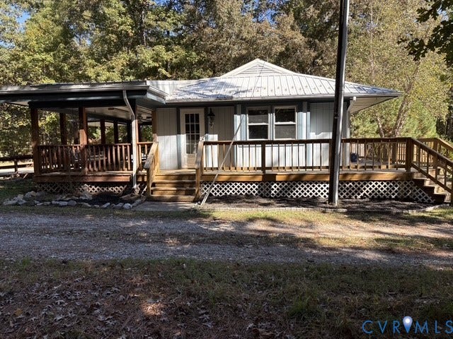 9012 Shawonodasee Road, Courthouse, Chesterfield, VA 23832 Single-story exterior featuring a metal roof, wraparound wood deck, lattice skirting, and vertical siding