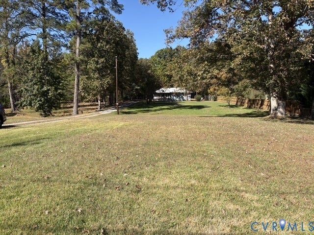 9012 Shawonodasee Road, Courthouse, Chesterfield, VA 23832 Expansive grass lawn featuring mature trees, a gravel driveway, and wood-panel fencing