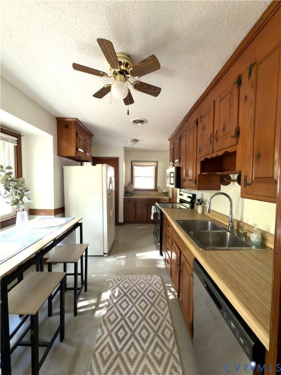 9012 Shawonodasee Road, Courthouse, Chesterfield, VA 23832 Kitchen featuring natural wood cabinetry, laminate countertops, dual-basin stainless steel sink with pull-down faucet, and built-in stainless steel dishwasher