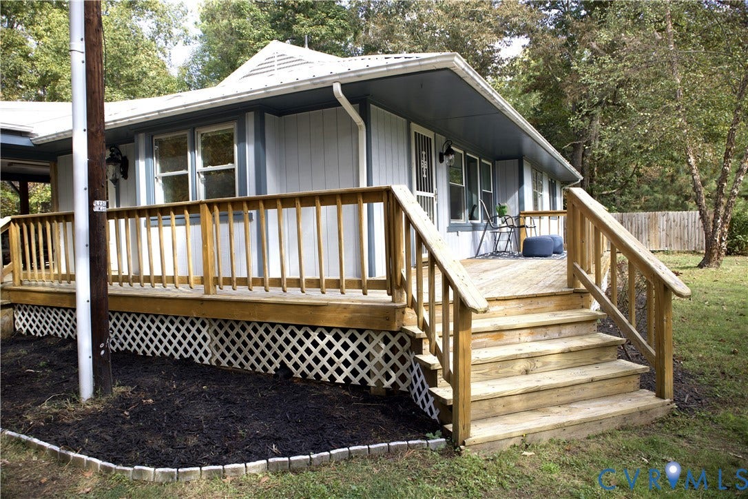 9012 Shawonodasee Road, Courthouse, Chesterfield, VA 23832 Exterior featuring wood-tone decking with stairs, lattice skirting, vertical siding, and a metal roof
