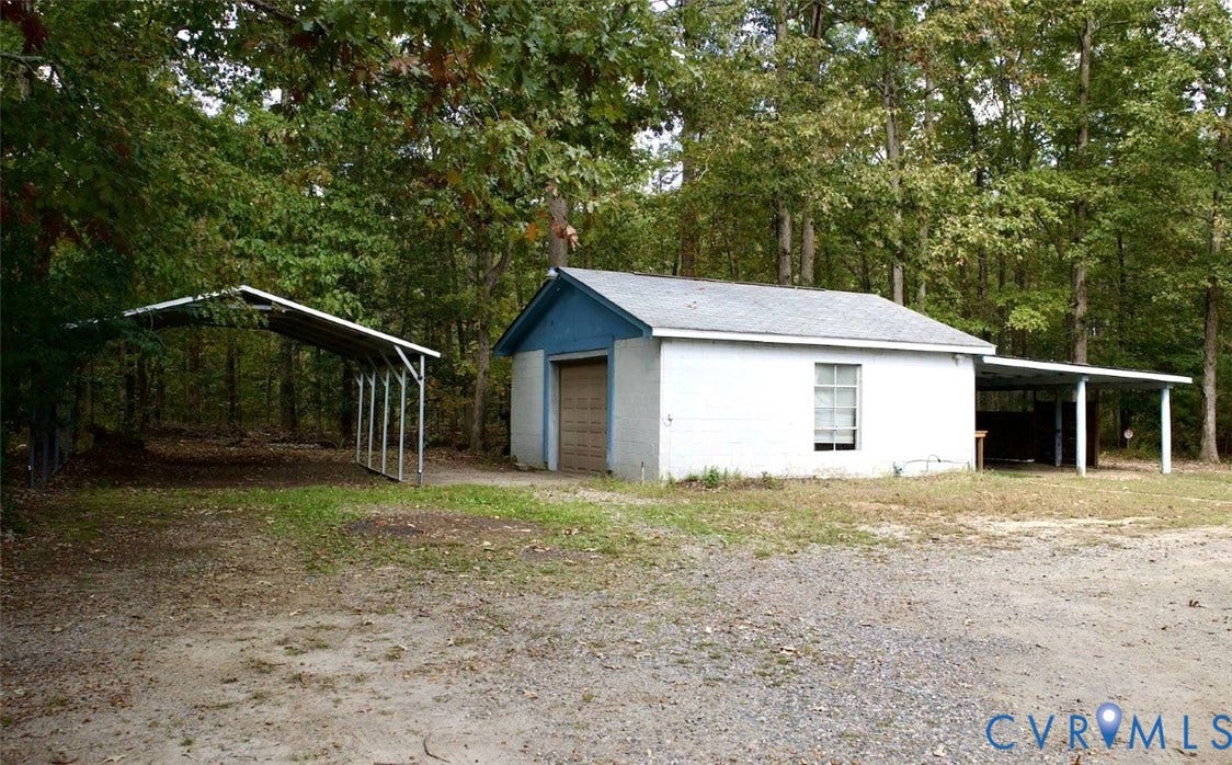 9012 Shawonodasee Road, Courthouse, Chesterfield, VA 23832 Detached outbuilding featuring a white brick exterior, pitched roof, single-bay garage, and two integrated metal-frame carports