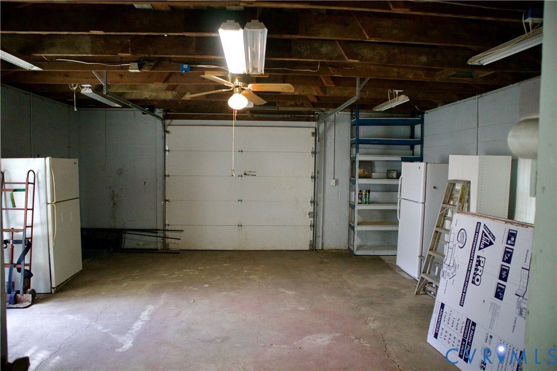 9012 Shawonodasee Road, Courthouse, Chesterfield, VA 23832 Garage featuring exposed joist ceiling, concrete flooring, overhead lighting, ceiling fan, and built-in metal shelving