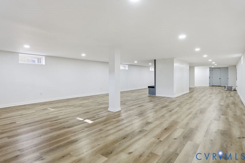 Open-concept interior featuring wood-finish flooring, recessed lighting, and multiple egress windows