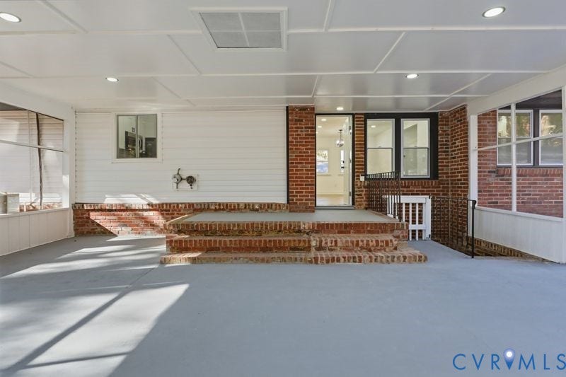 Covered patio featuring a finished ceiling with recessed lighting, tiered brick steps, exterior brick and siding construction, and integrated screen enclosures