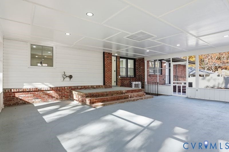 Covered patio featuring a paneled ceiling with recessed lighting, brick masonry accents, stepped brick entry, and screen-enclosed walls