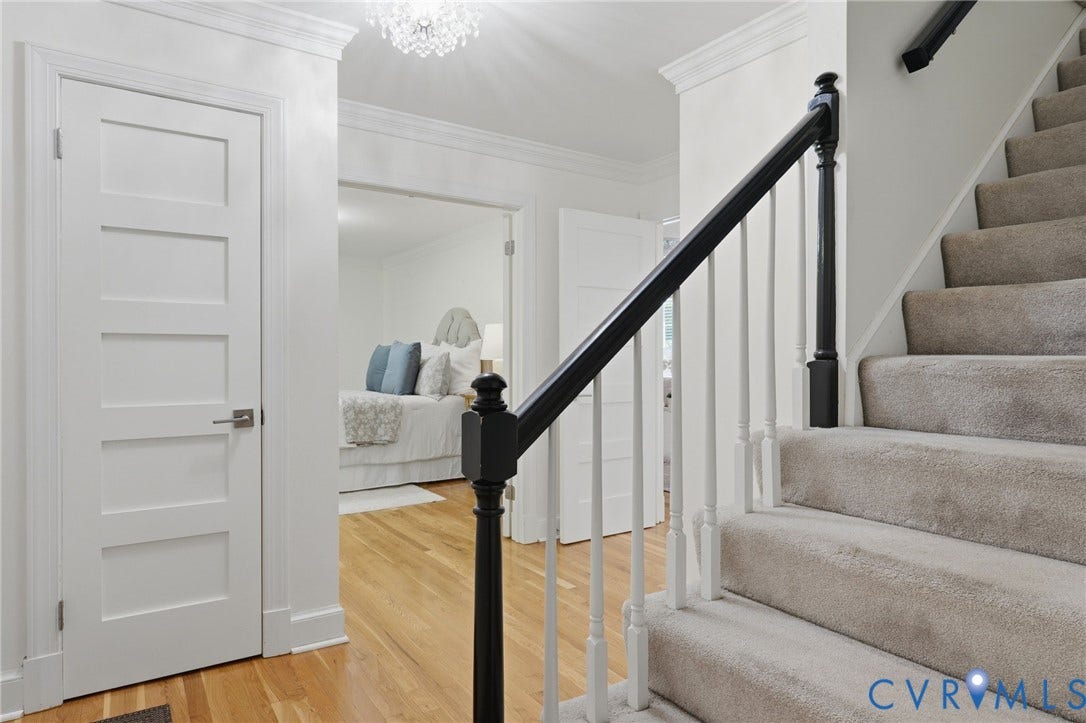 2311 Castle Hill Road, Midlothian, VA 23113 Foyer featuring wood-finish flooring, a staircase with carpeted treads, a high-contrast balustrade, crown molding, and a crystal chandelier