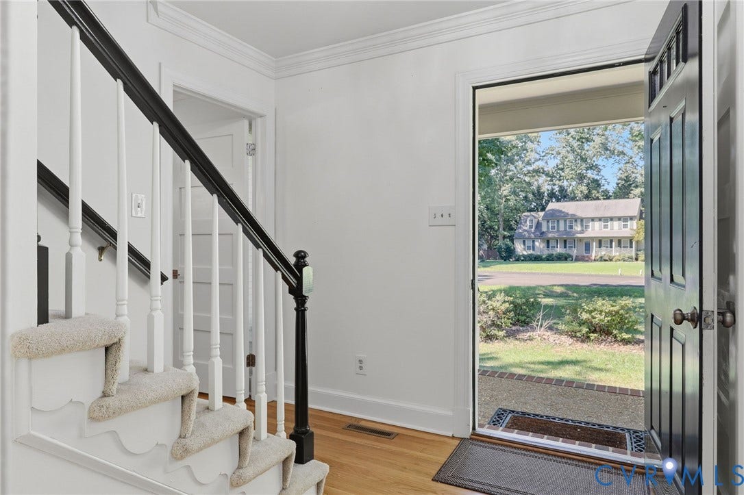2311 Castle Hill Road, Midlothian, VA 23113 Foyer featuring wood-finish flooring, a staircase with a contrasting dark railing and white balusters, and a paneled entry door with transom detailing