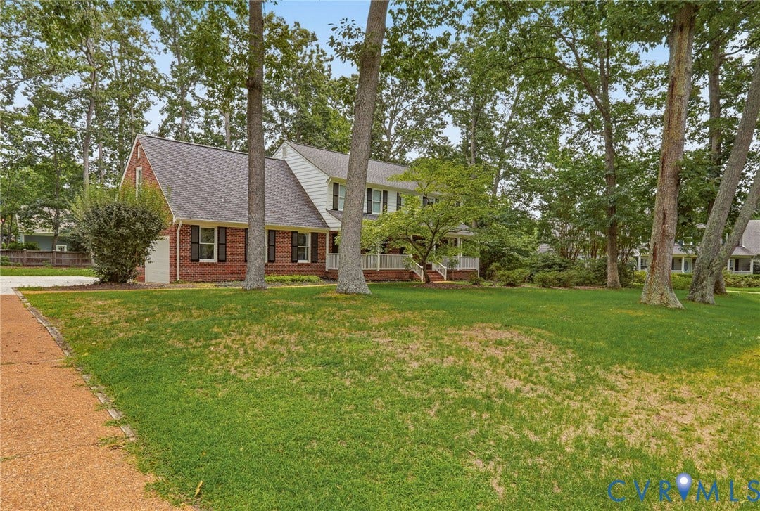 2311 Castle Hill Road, Midlothian, VA 23113 Two-story residence featuring a brick and siding exterior, front porch with white railing, and mature trees situated on a spacious lot