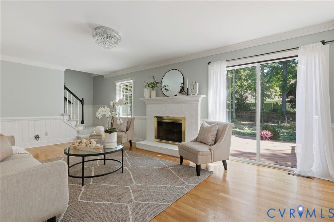 2311 Castle Hill Road, Midlothian, VA 23113 Living area featuring wood-finish flooring, a painted brick fireplace with a mantel, wainscoting, a crystal flush-mount light fixture, and sliding glass doors
