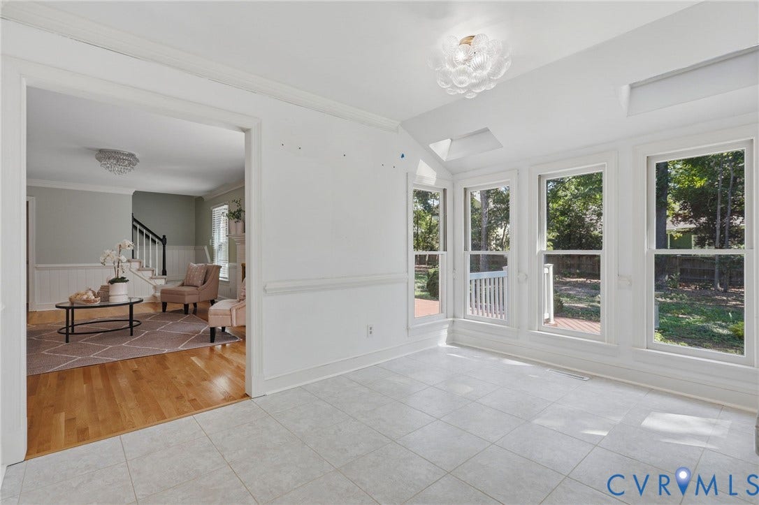 2311 Castle Hill Road, Midlothian, VA 23113 Sunroom featuring large windows, vaulted ceiling, skylights, tile flooring, and decorative flush-mount lighting