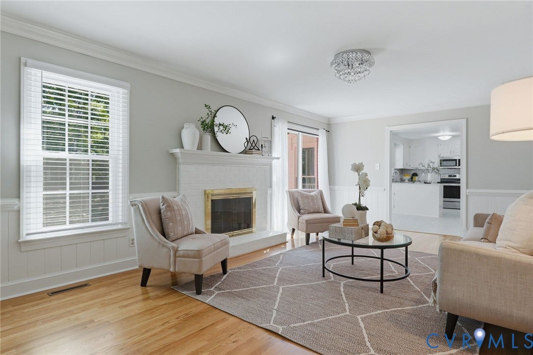 2311 Castle Hill Road, Midlothian, VA 23113 Living room featuring wood-finish flooring, white wainscoting, crown molding, and a fireplace with a mantel