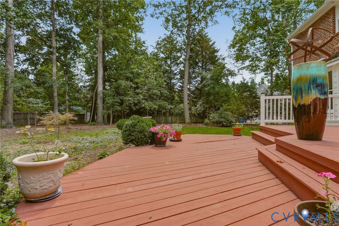 2311 Castle Hill Road, Midlothian, VA 23113 Multi-level wood deck featuring white balustrades and an expansive backyard with mature trees and professional landscaping
