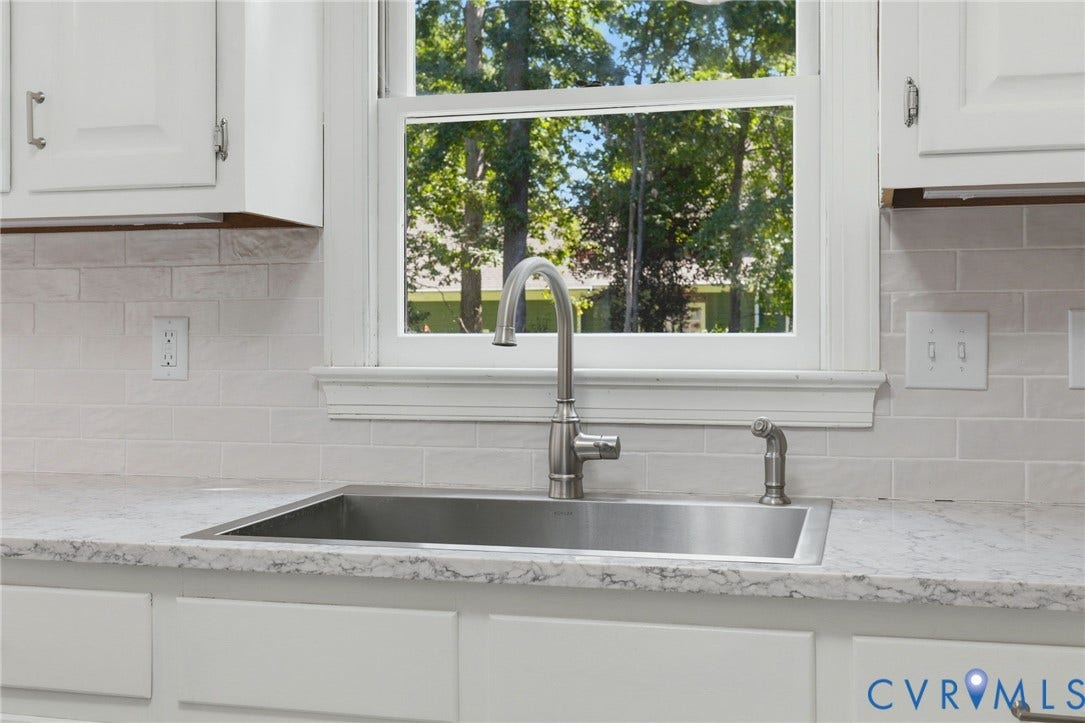 2311 Castle Hill Road, Midlothian, VA 23113 Kitchen featuring white shaker-style cabinetry, a stone-patterned countertop, a stainless steel undermount sink with a high-arch gooseneck faucet, and a light-toned brick-style backsplash