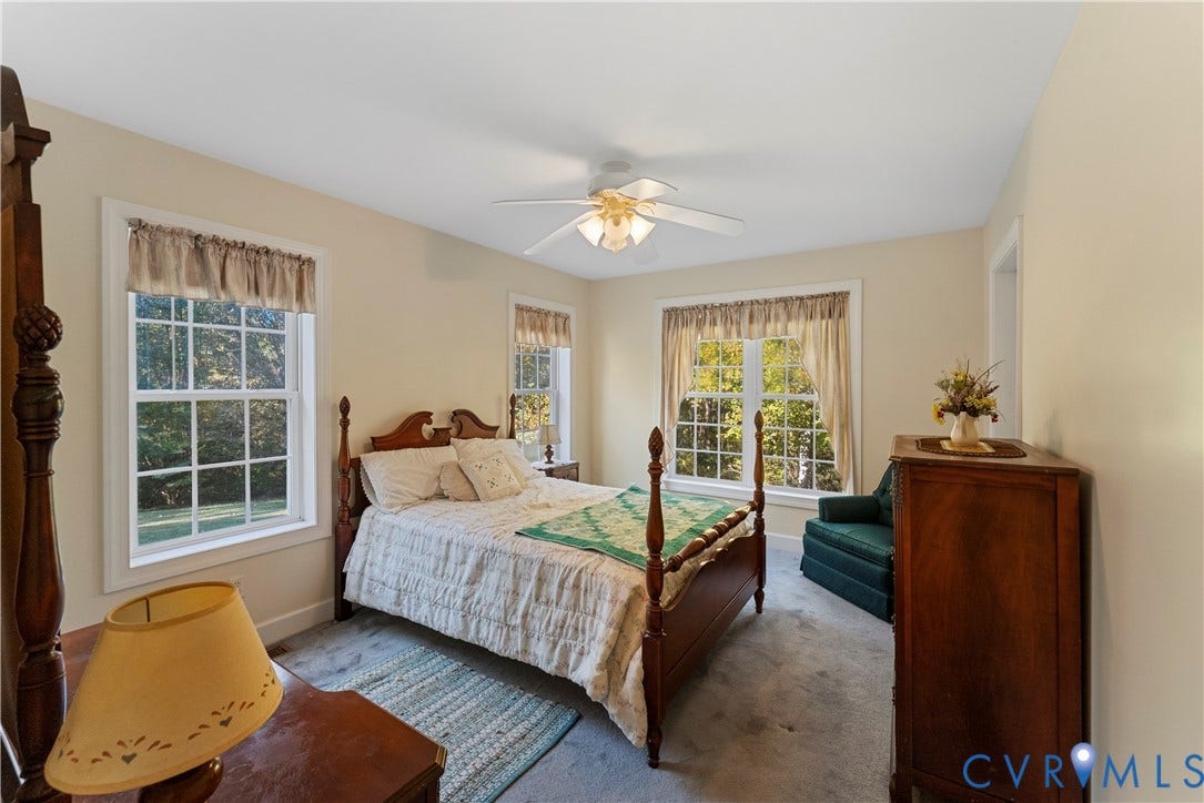 Spacious room featuring neutral wall tones, multi-pane windows, and a central ceiling fan with integrated lighting