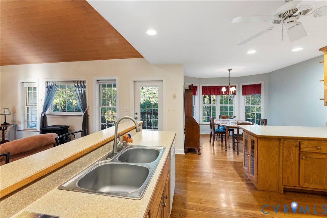 Kitchen featuring a double-basin stainless steel sink, wood-finish cabinetry, neutral countertops, wood-paneled vaulted ceiling, and recessed lighting