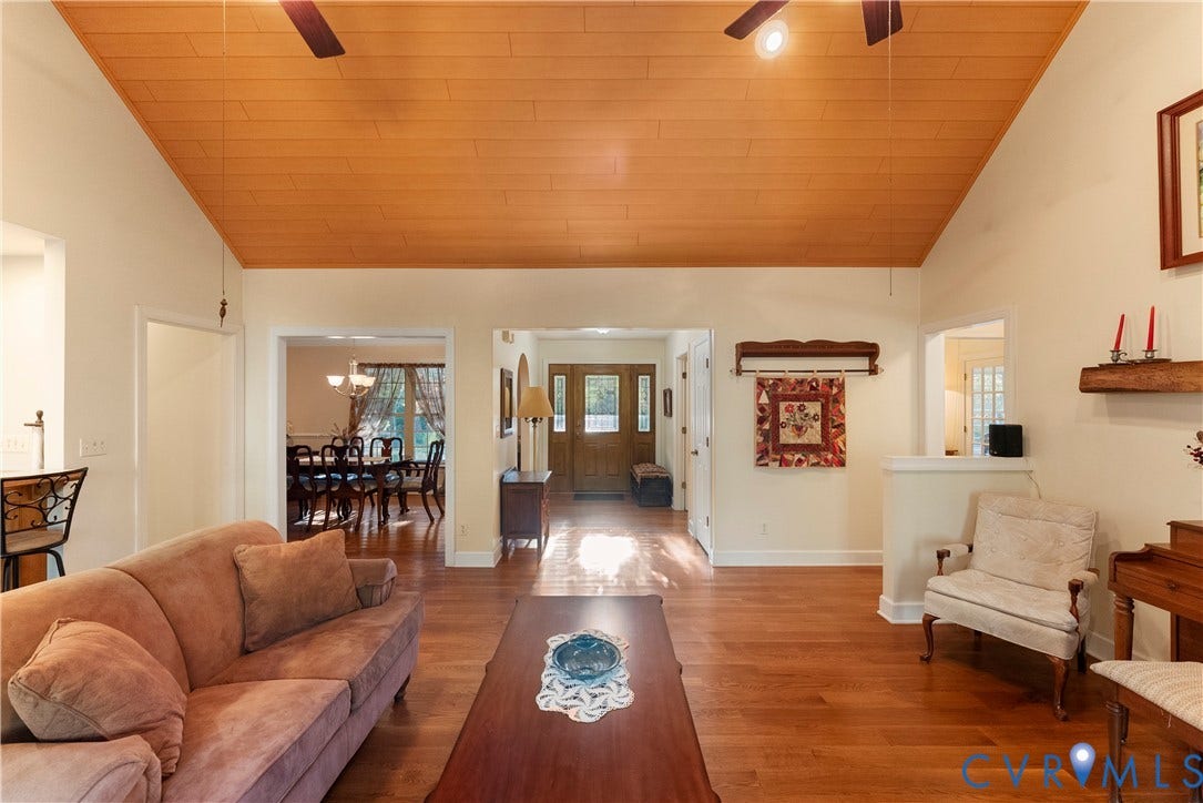 Vaulted ceiling with wood paneling, wood-finish flooring, and a multi-pane glass entry door