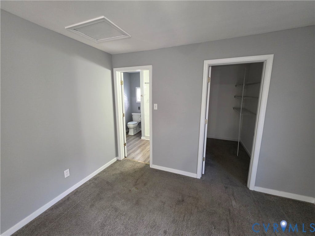 2406 Trenton Street, Hopewell, VA 23860 Neutral-toned interior featuring wall-to-wall carpeting, wood-finish flooring in the secondary space, and a walk-in closet with built-in shelving