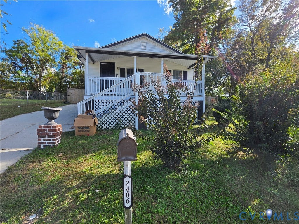 2406 Trenton Street, Hopewell, VA 23860 Exterior facade featuring a covered front porch, white lattice skirting, concrete driveway, and brick-column mailbox mount