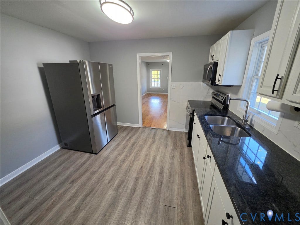 2406 Trenton Street, Hopewell, VA 23860 Kitchen featuring stone countertops, stainless steel refrigerator, white cabinetry with matte black hardware, wood-finish flooring, and a double-basin stainless steel sink