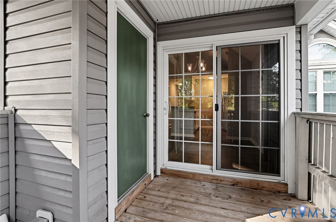 910 Rue Marseille, Les Chateaux, Chesapeake, VA 23320 Covered balcony featuring horizontal lap siding, wood-finish decking, and a sliding glass door with a grid pattern