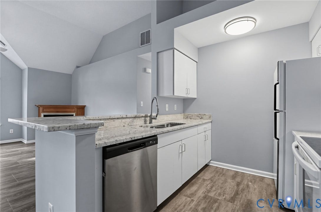 910 Rue Marseille, Les Chateaux, Chesapeake, VA 23320 Kitchen featuring a peninsula with stone-finish countertops, stainless steel dishwasher, white cabinetry, wood-finish flooring, and vaulted ceiling