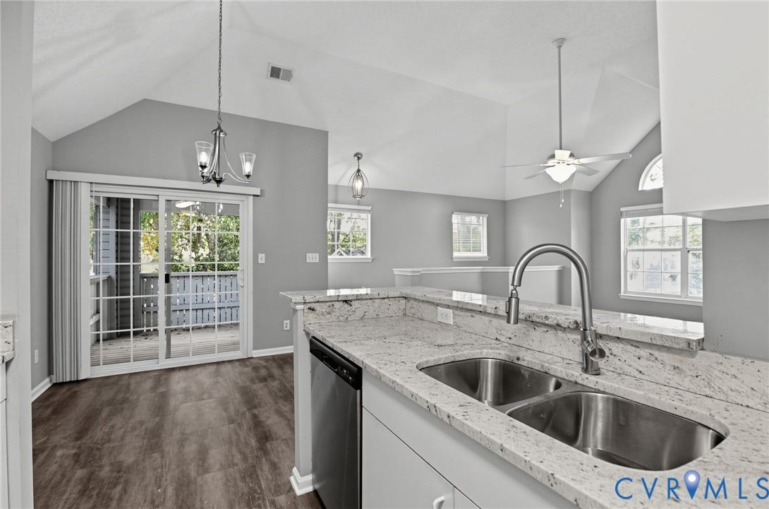 910 Rue Marseille, Les Chateaux, Chesapeake, VA 23320 Kitchen featuring stone countertops, a dual-basin stainless steel sink with a high-arch faucet, vaulted ceilings, wood-finish flooring, and sliding glass doors