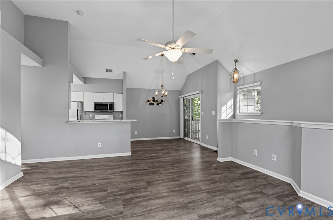 910 Rue Marseille, Les Chateaux, Chesapeake, VA 23320 Open concept living area featuring vaulted ceilings, wood-finish flooring, a ceiling fan with integrated lighting, and a breakfast bar overlooking the kitchen