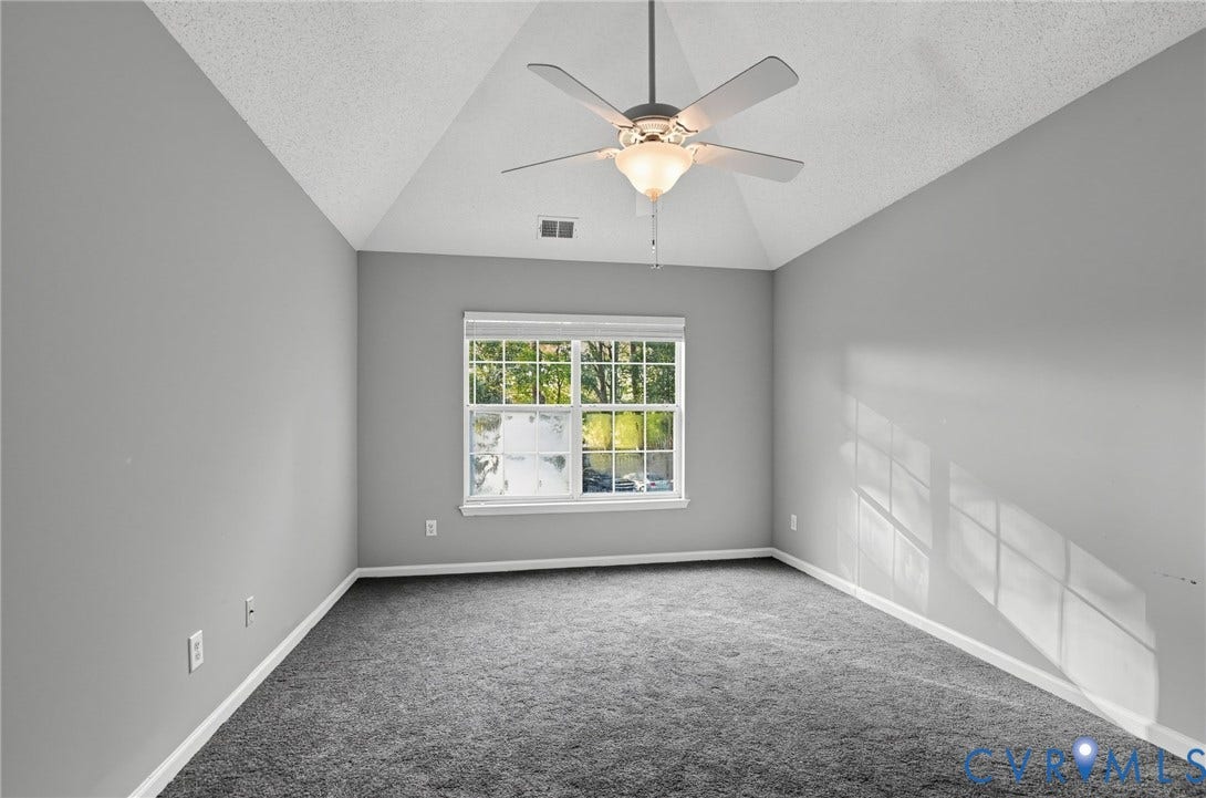 910 Rue Marseille, Les Chateaux, Chesapeake, VA 23320 Vaulted ceiling featuring a central multi-blade ceiling fan with integrated light fixture, neutral wall palette, wall-to-wall carpeting, and a double-pane window