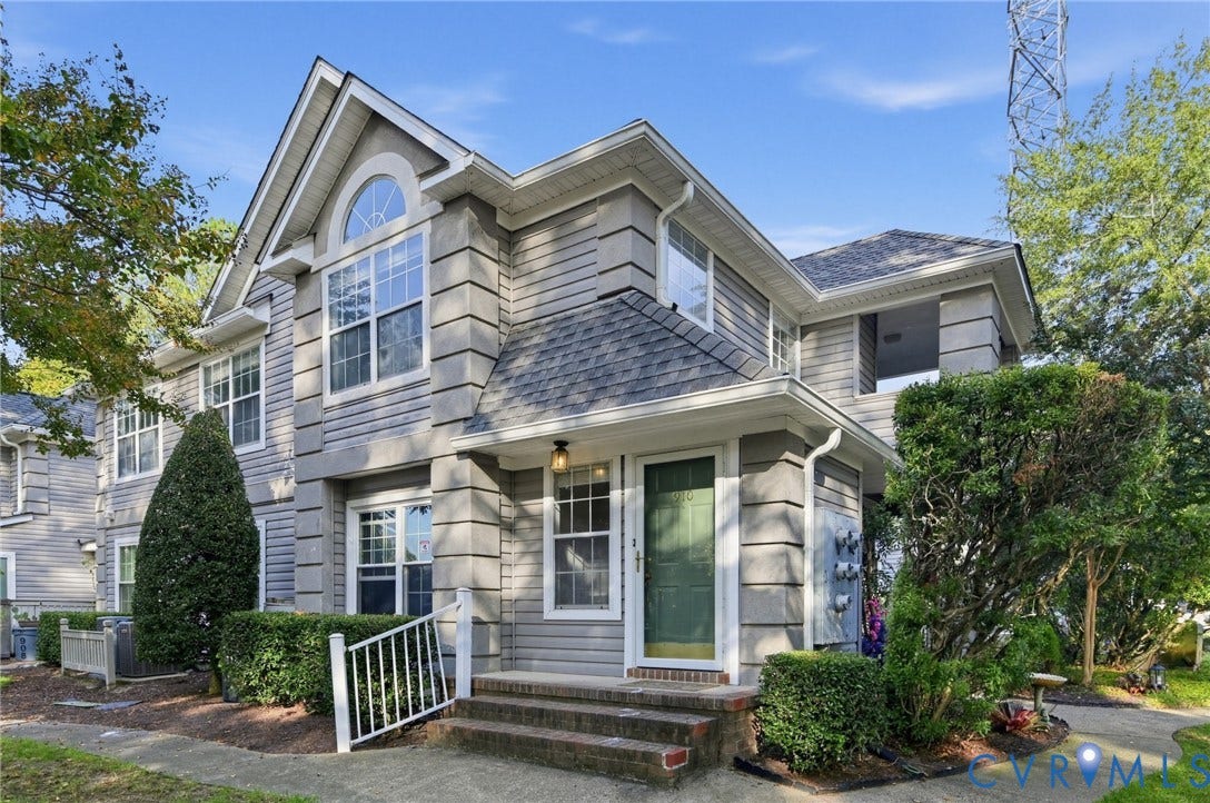 910 Rue Marseille, Les Chateaux, Chesapeake, VA 23320 Multi-story exterior featuring gray lap siding, decorative corner quoins, an arched window, a gabled roofline, and a covered front entry with brick steps