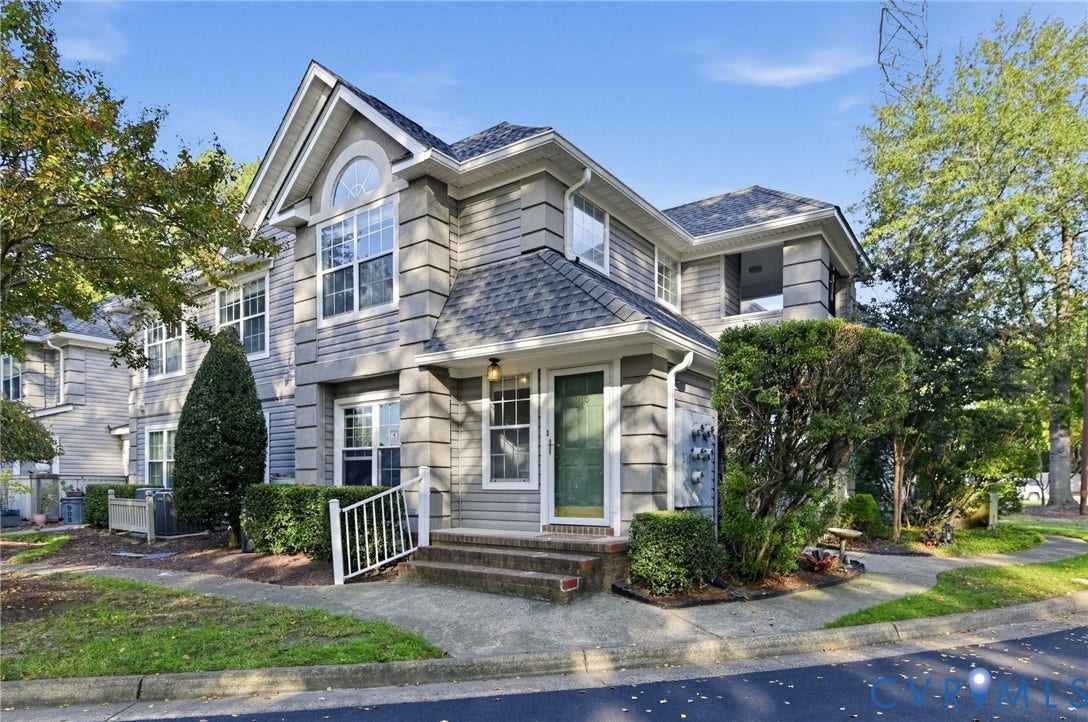 910 Rue Marseille, Les Chateaux, Chesapeake, VA 23320 Multi-level residence featuring gray lap siding, corner quoins, an arched window, and a covered entryway with a brick-stepped stoop