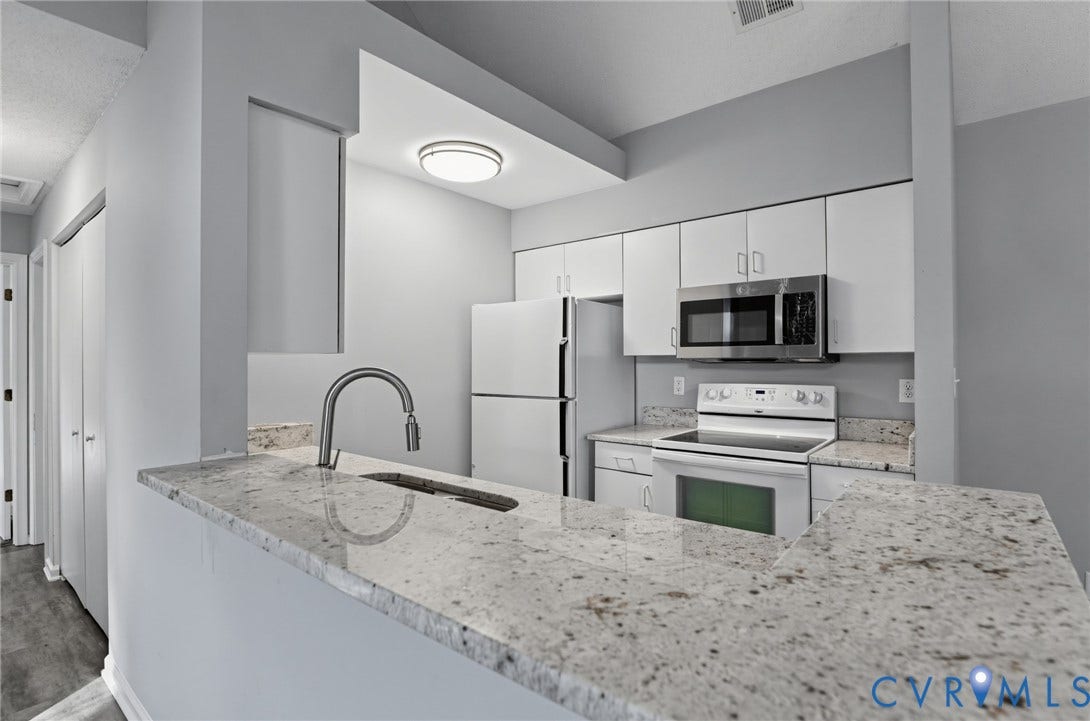 910 Rue Marseille, Les Chateaux, Chesapeake, VA 23320 Kitchen featuring stone-finish countertops, a stainless steel undermount sink with a gooseneck faucet, white cabinetry, and stainless steel microwave